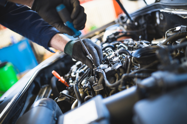 Close up hands of unrecognizable mechanic doing car service and maintenance.