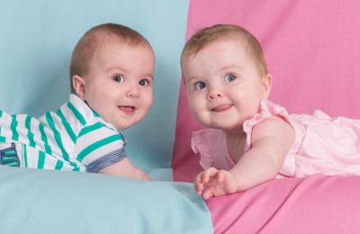 brother and sister - twins babies girl and boy on pink and blue background