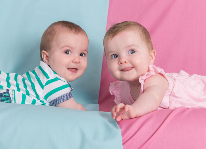 brother and sister - twins babies girl and boy on pink and blue background