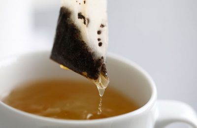 Hot water trickling down from herbal potion teabag close-up