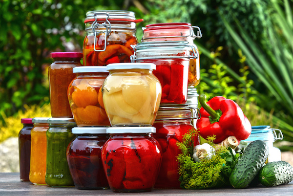 Jars of pickled vegetables and fruits in the garden. Marinated food.