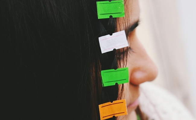 Closeup image of young womans hair attached to empty price tag l